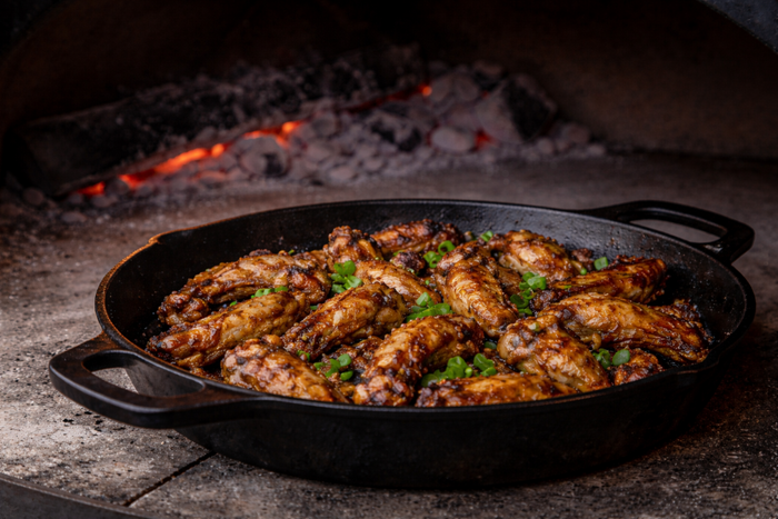 Baked chicken wings in a cast iron skillet in the oven